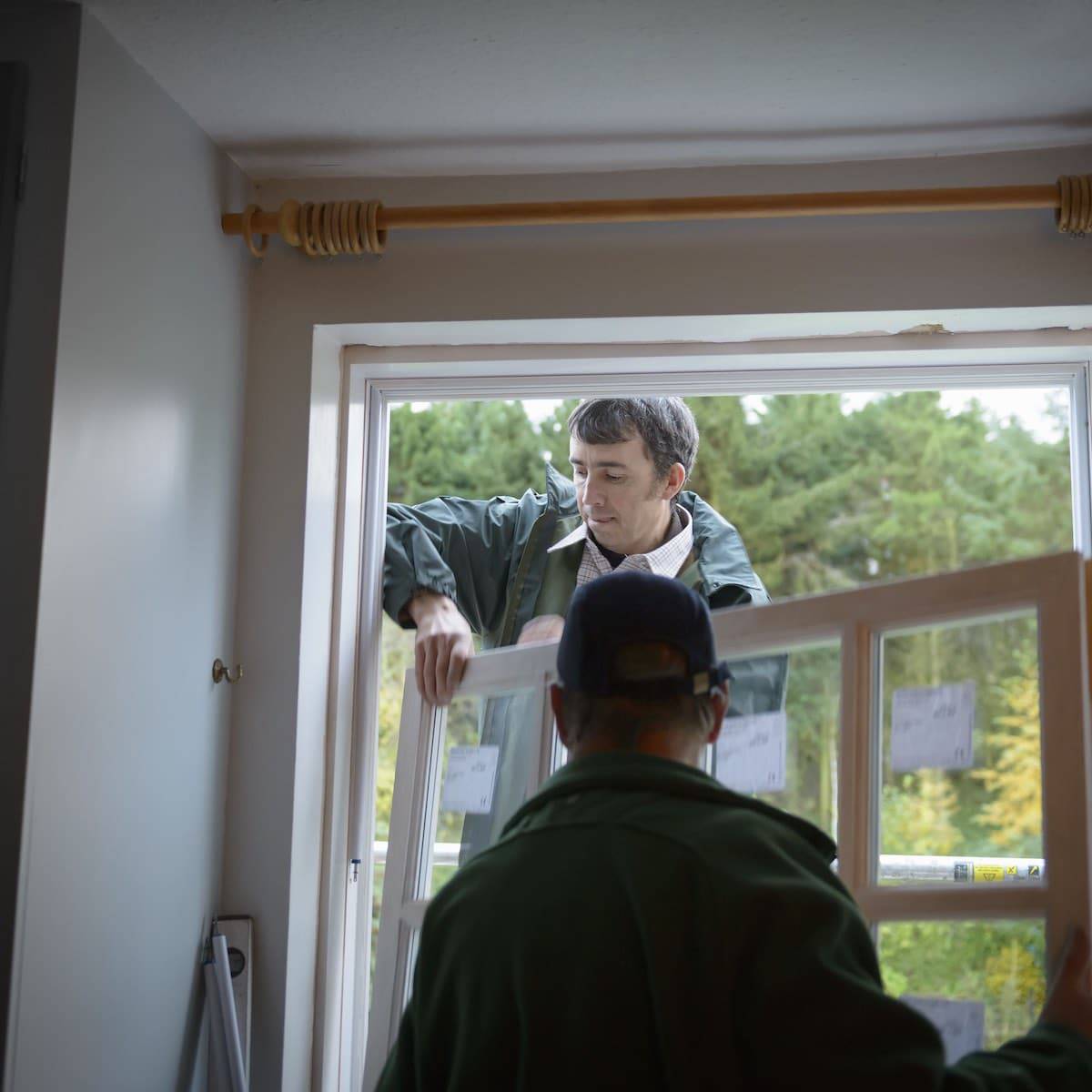 Installers fitting new double glazed windows in a UK home